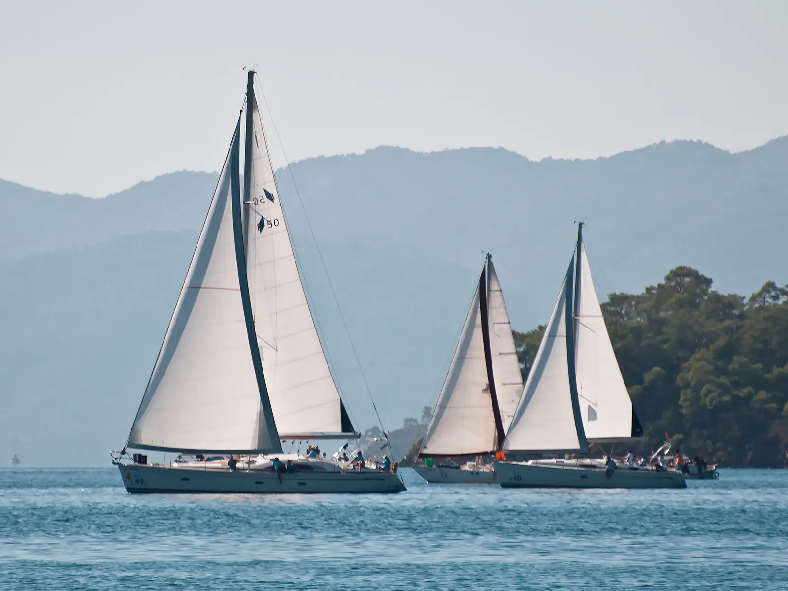 Göcek Regatta sırasında yarışan yelkenlilerin deniz üzerindeki aksiyon dolu görüntüsü.