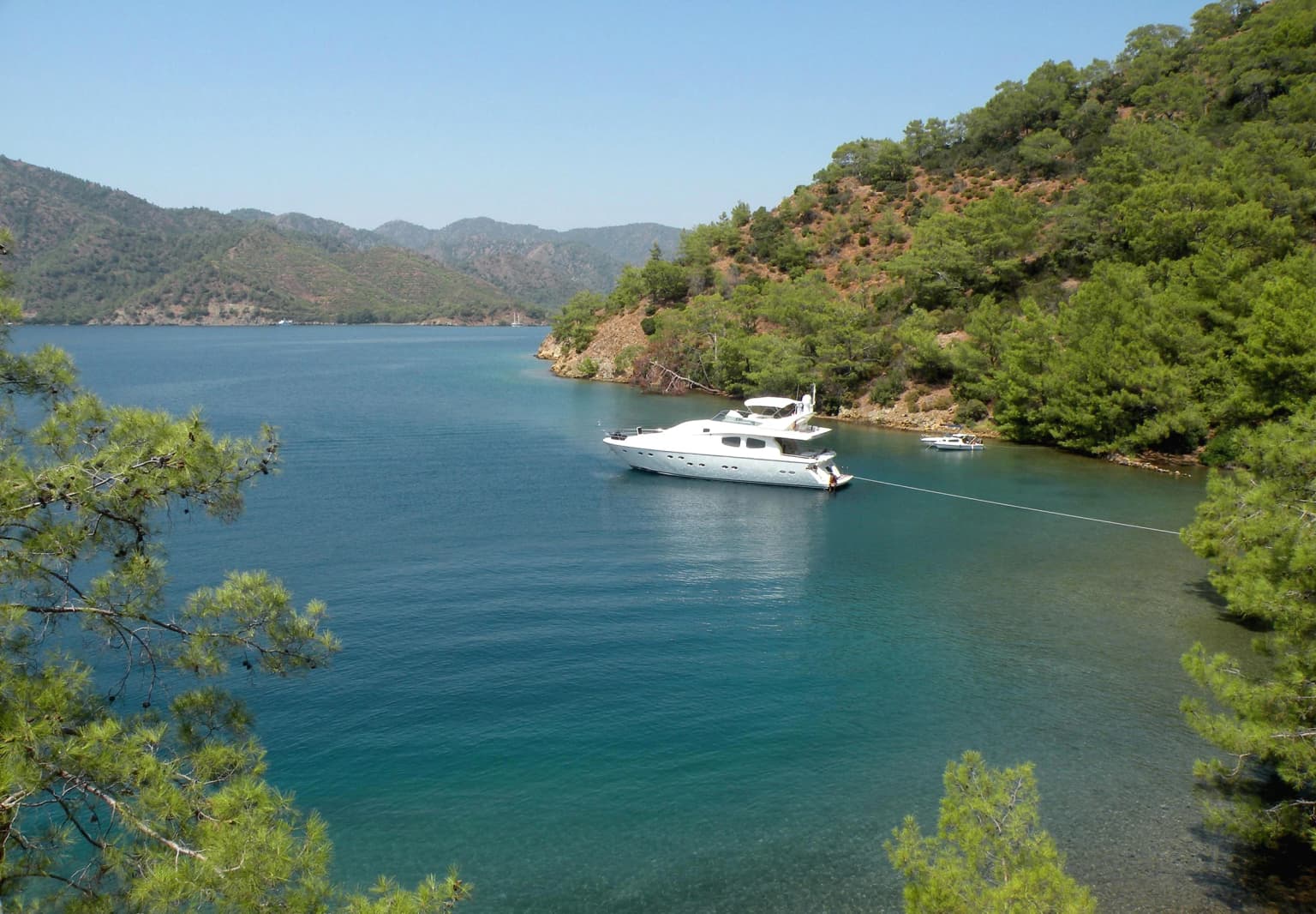 Göcek Adası Büyük Koy'da demirlemiş tekneler ve turkuaz deniz. Göcek tekne turu ve yat rotalarının popüler yüzme ve mola noktası.